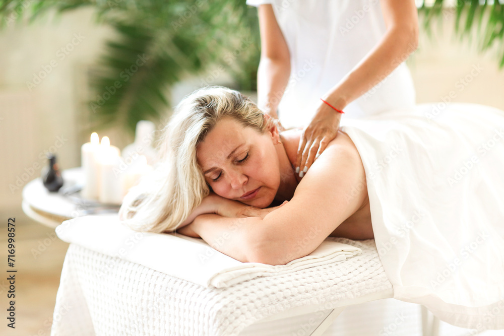 Obraz premium Asian masseuse massaging middle age female client