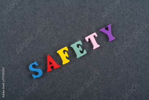 SAFETY word on black board background composed from colorful abc alphabet block wooden letters, copy space for ad text. Learning english concept.