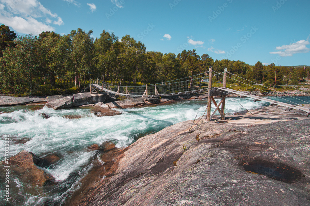 Abenteuerliche Hängebrücke über Wildwasserfluss Abenteuerliche Hängebrücke über Wildwasserfluss