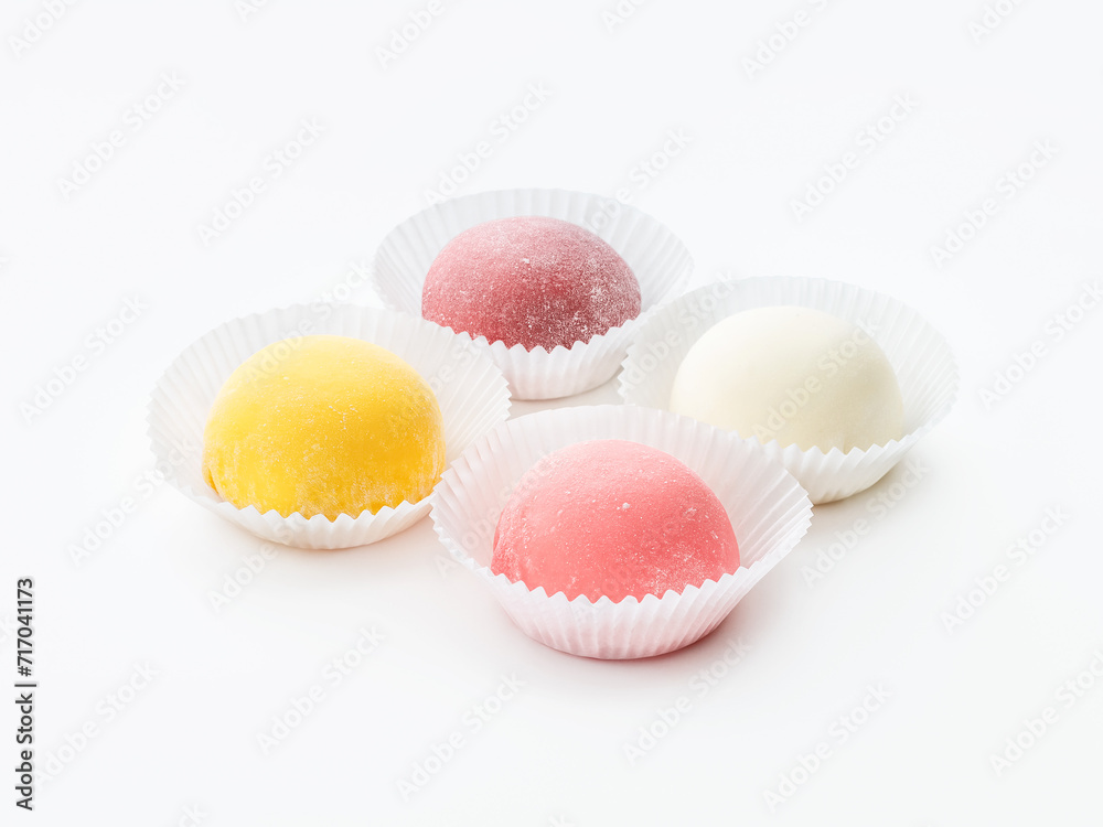 Mochi, 4 pieces of different colors; pink, white and yellow on a white background in paper forms. Side and top view. Mochi, 4 pieces of different colors; pink, white and yellow on a white background in paper forms. Side and top view.