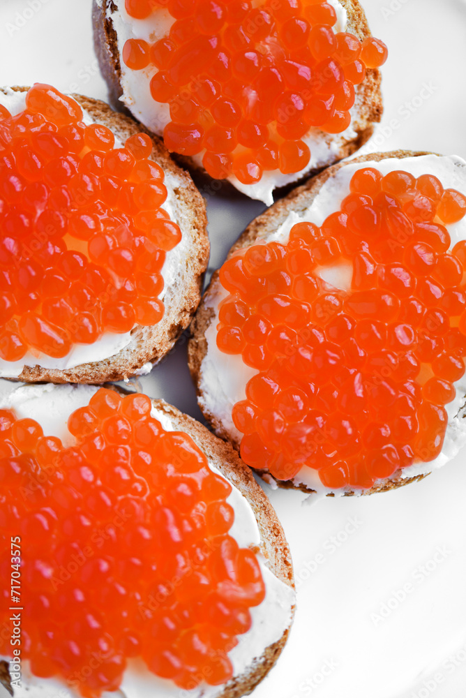 Red salmon caviar on bread and butter. A sandwich with caviar and butter on a plate. Red salmon caviar on bread and butter. A sandwich with caviar and butter on a plate.
