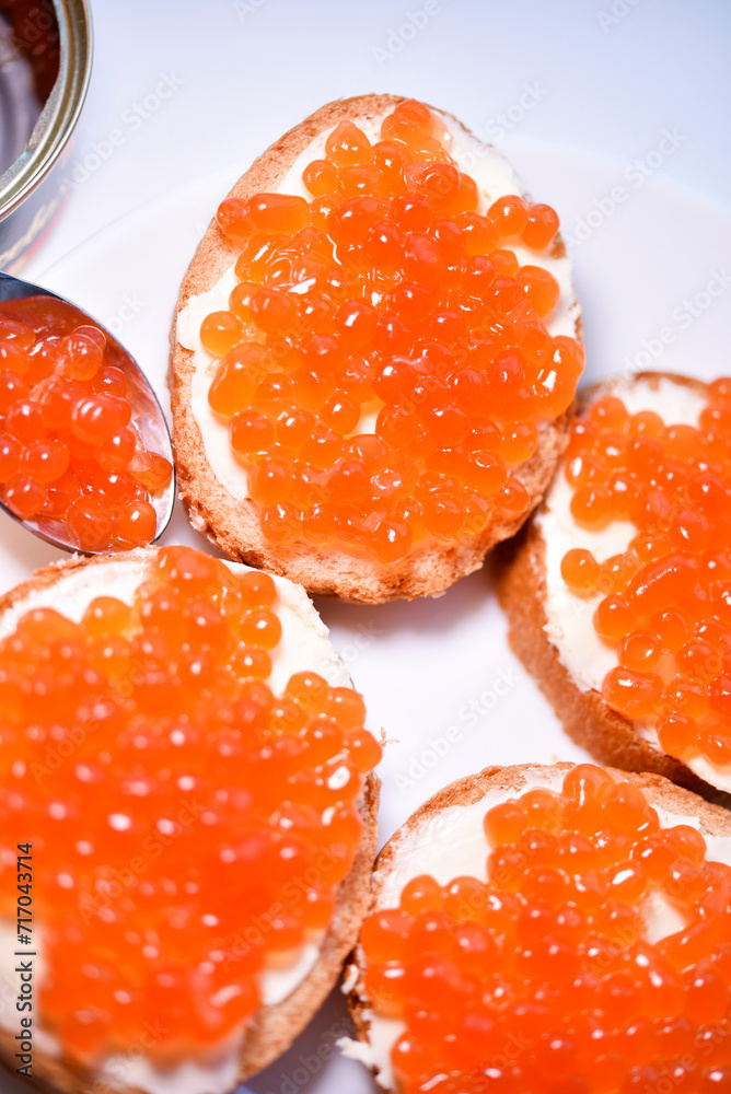 Red salmon caviar on bread and butter. A sandwich with caviar and butter on a plate. Red salmon caviar on bread and butter. A sandwich with caviar and butter on a plate.