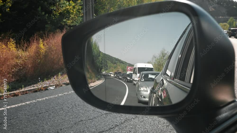 Large queue of moving cars at Greek-Bulgarian border post, reflected in side mirror of car in summer during abnormal heat Large queue of moving cars at Greek-Bulgarian border post, reflected in side mirror of car in summer during abnormal heat