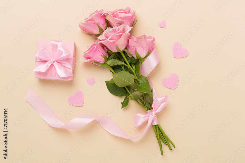 Pink roses with hearts and gift box on color background, top view. Valentines day concept