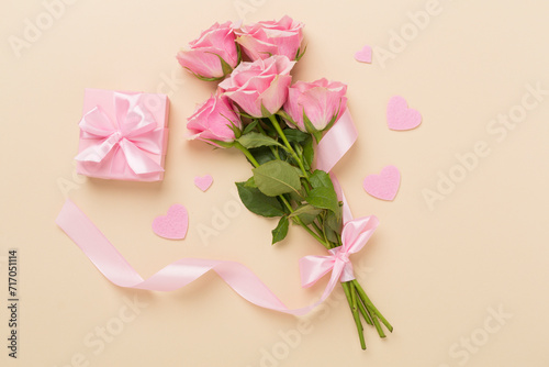 Pink roses with hearts and gift box on color background, top view. Valentines day concept © Liami