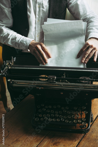 A writer putting blank pages into a typewriter