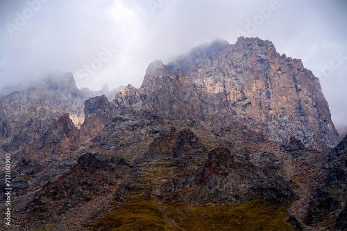 A beautiful rocky mounains in a foggy cloudy weather in the evening.