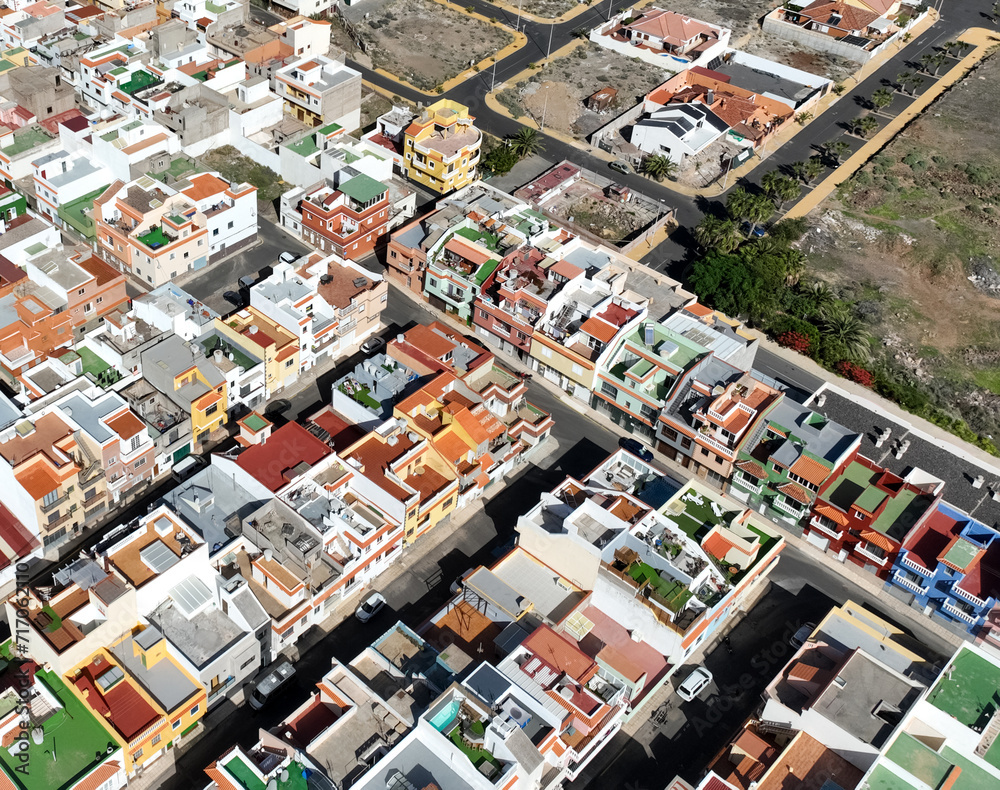 Colored roofs and houses in the village on Tenerife island, top view from a drone.