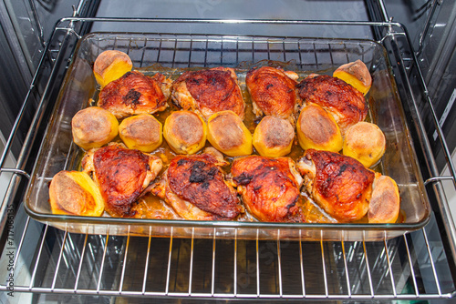 chicken thighs with potatoes baked in the oven on the grill close-up