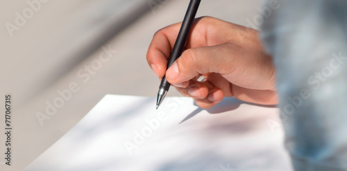 Man is writing notes on a white paper  hands closeup.