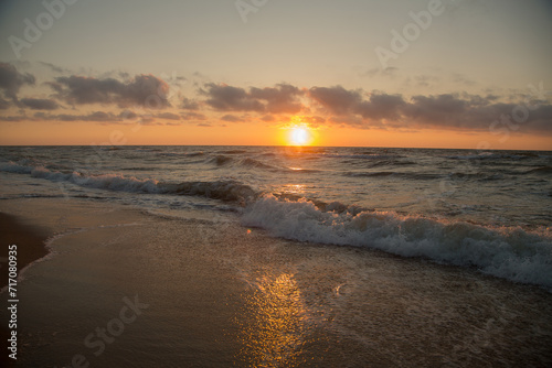 Fototapeta Naklejka Na Ścianę i Meble -  Sunrise from across the sea the water is dark and golden.