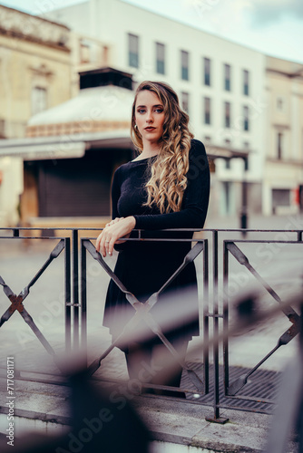Chica joven con pelo rizado posando en la calle