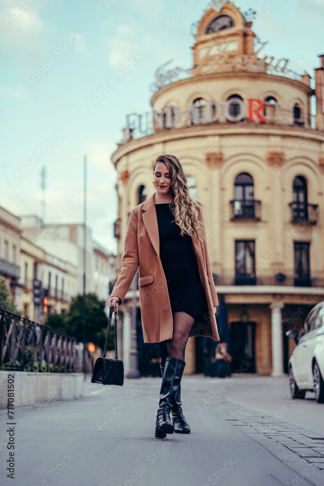 Chica joven con pelo rizado posando en la calle