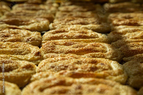 Close-up of golden-baked sesame seed pastries, fresh from the oven, ideal for bakery or culinary themes