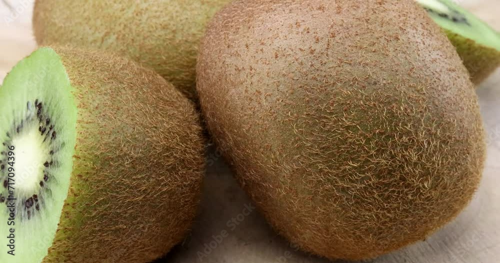 Video of two whole and halved delicious kiwi fruits in close-up on a turntable