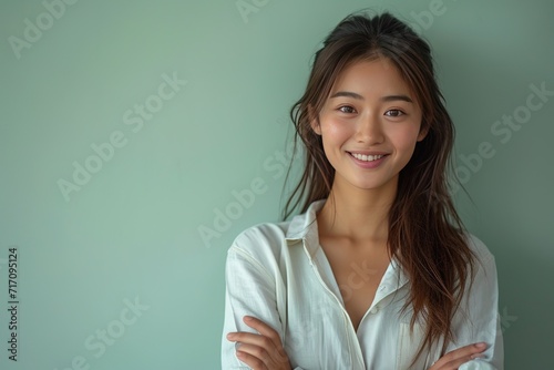 Portrait of successful Asian woman with arms crossed and smile isolated over light green background, Young lady smiling and looking at camera, Happy feeling concept