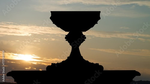 Sacred graal. or Holy grail in Silhouette at Sunrise, Time Lapse with Colorful Clouds