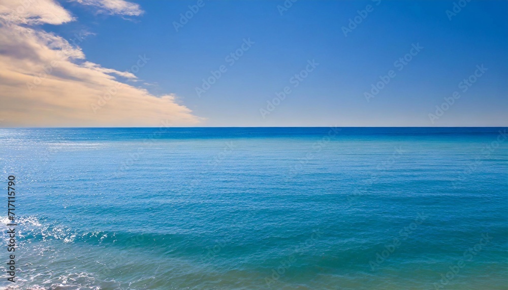 The blue sea to the horizon where it meets the clear blue sky.