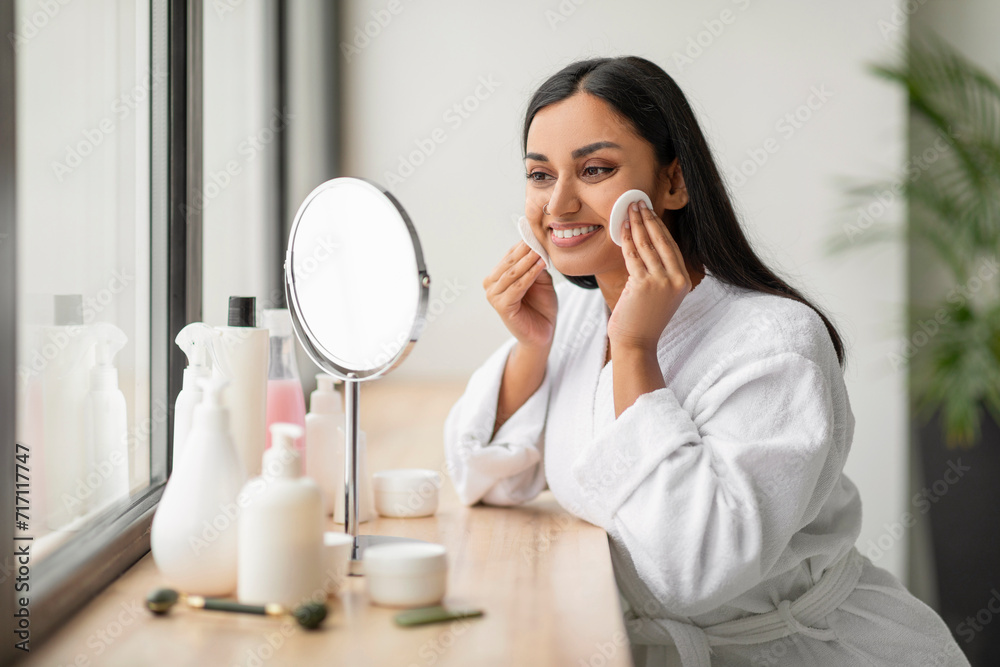 Attractive young indian woman using cotton pads at bathroom Attractive young indian woman using cotton pads at bathroom