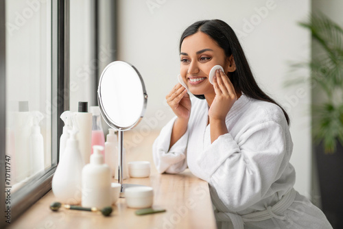 Attractive young indian woman using cotton pads at bathroom