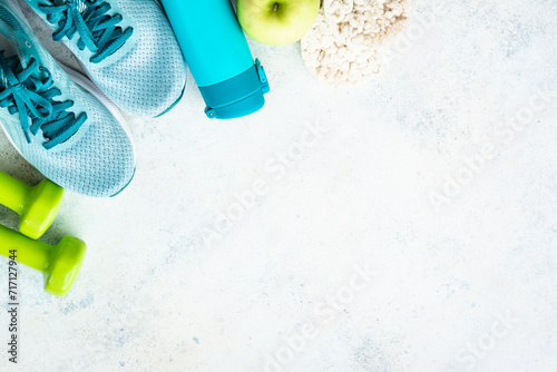 Fitness equipment, flat lay image. Sneakers, dumbbells, towel and green apple. Training, workout and fitness concept. photo