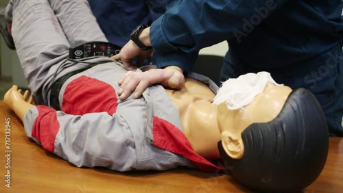 Rescuer doing massage manikin for training lying on table photo