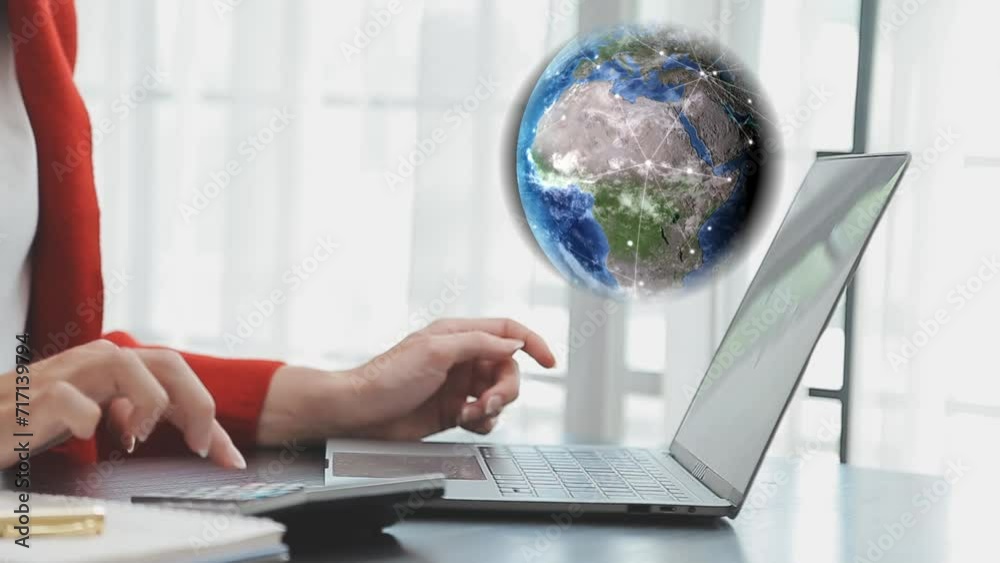 Mujer de negocios observa el globo terráqueo girando con puntos que se van conectando unos con otros, mientras trabaja en su laptop, hace cálculos y toma nota.