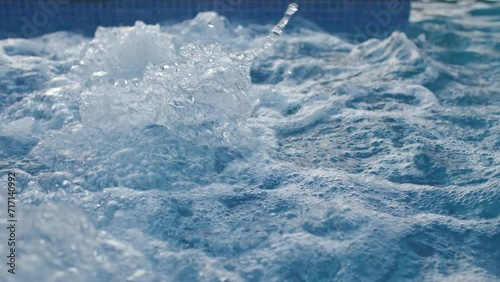 In this slow motion video, bubbles gracefully rise in a working jacuzzi within a swimming pool, embodying the essence of relaxation and spa indulgence.