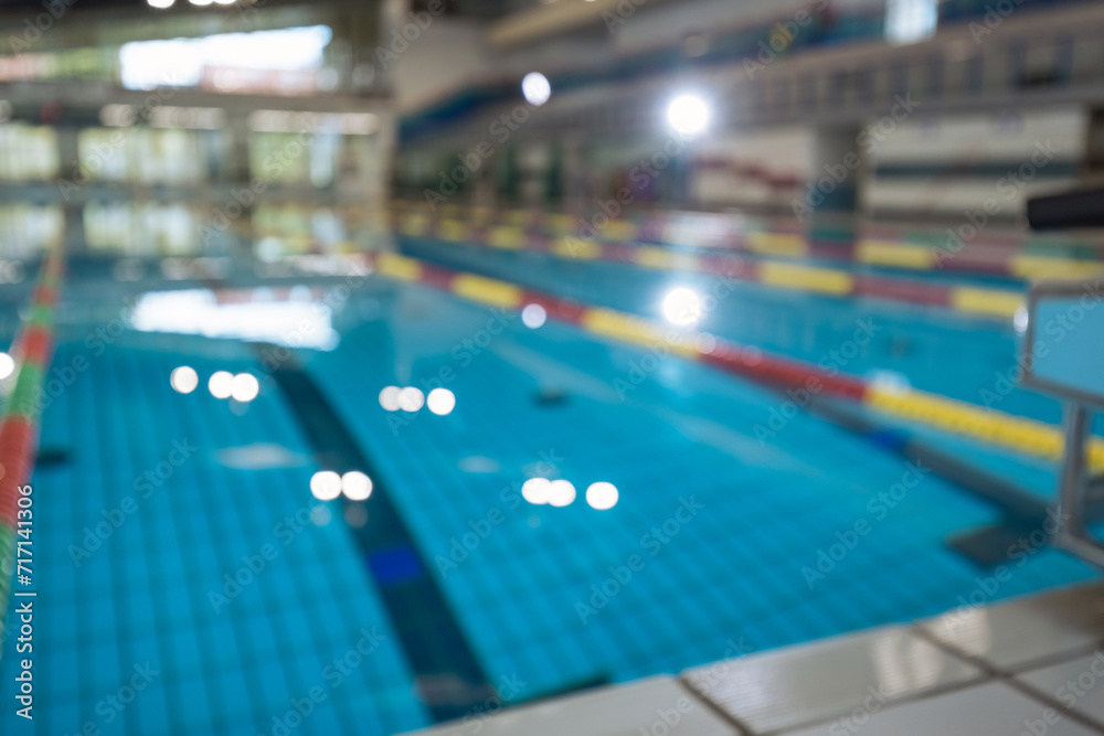 Defocused empty sport competition swimming pool with lanes, lens blur