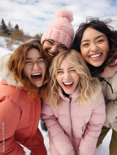 Happy friends taking selfie outdoors during winter with smartphone and winter clothing. Happy young friends laughing and having fun, different ethnicity