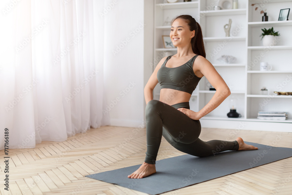 Happy young asian woman doing lunges exercise while training at home Happy young asian woman doing lunges exercise while training at home