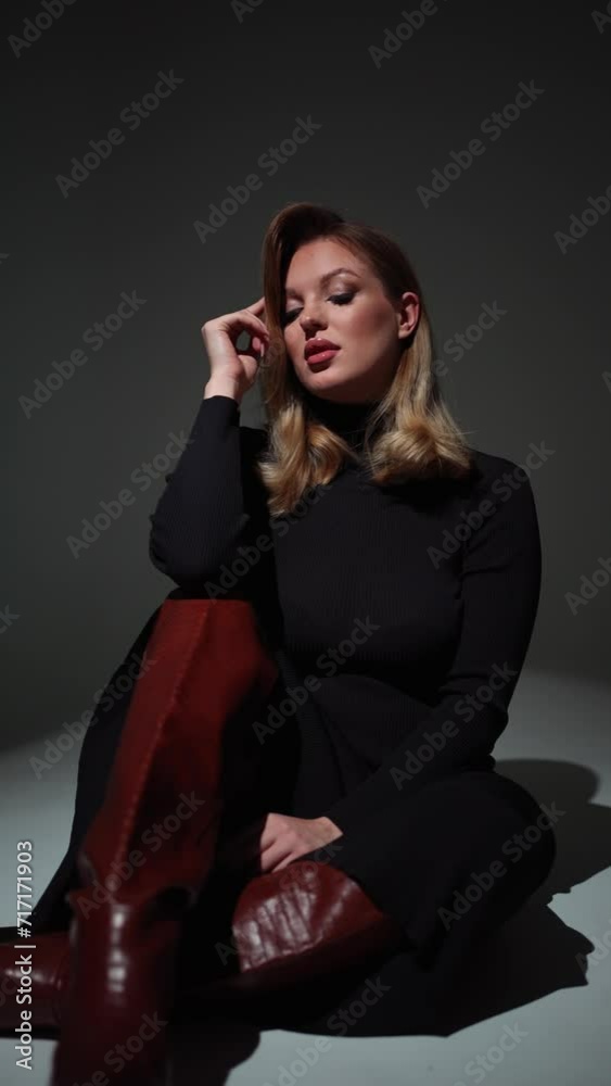 Elegant woman in a black dress in the studio on a gray background Elegant woman in a black dress in the studio on a gray background