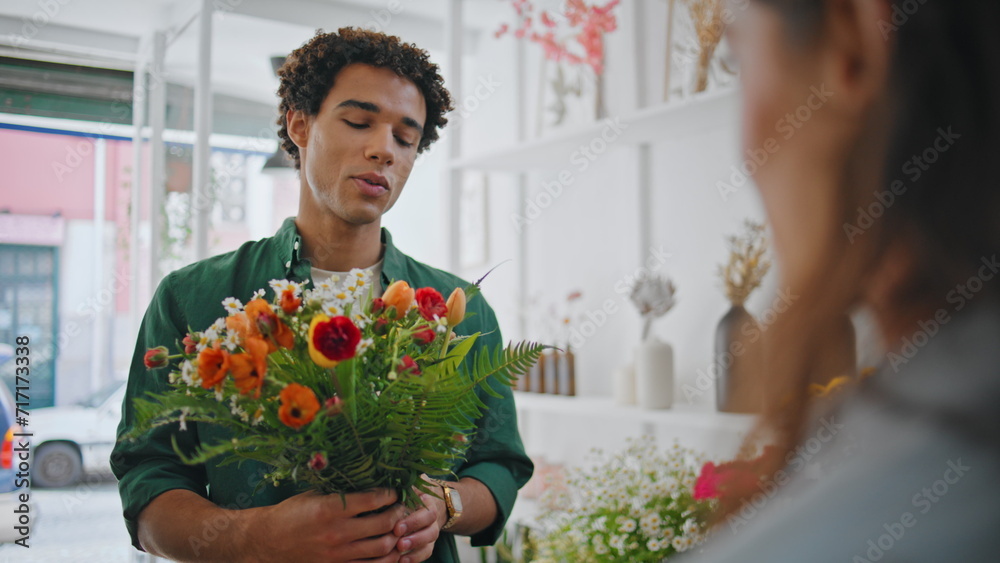 Joyful customer present flower to seller lady in plant store. Romantic concept. Joyful customer present flower to seller lady in plant store. Romantic concept.
