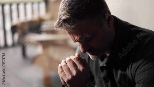 Adult man folded his palms and prays. Happy father clasped two arms and dreaming about second child in family. Young religious dad believe in gods justice