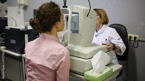 Ophthalmologist configures device before examination of the patient photo