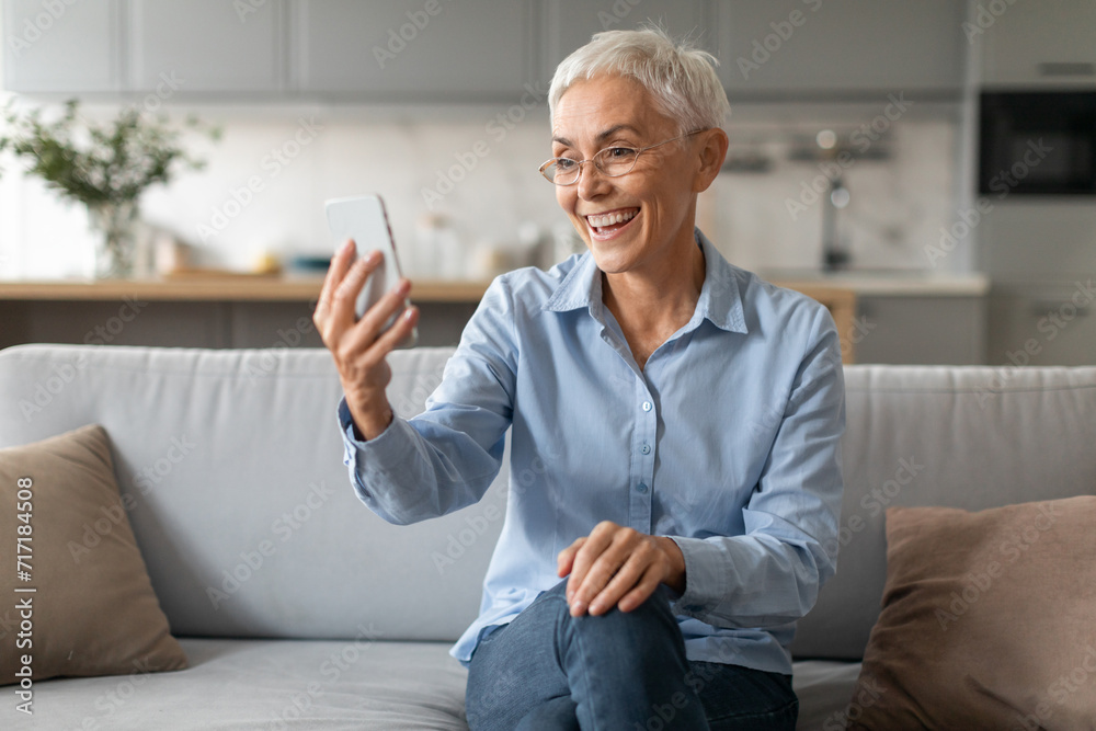 senior woman holding and using mobile phone wearing eyeglasses indoor senior woman holding and using mobile phone wearing eyeglasses indoor