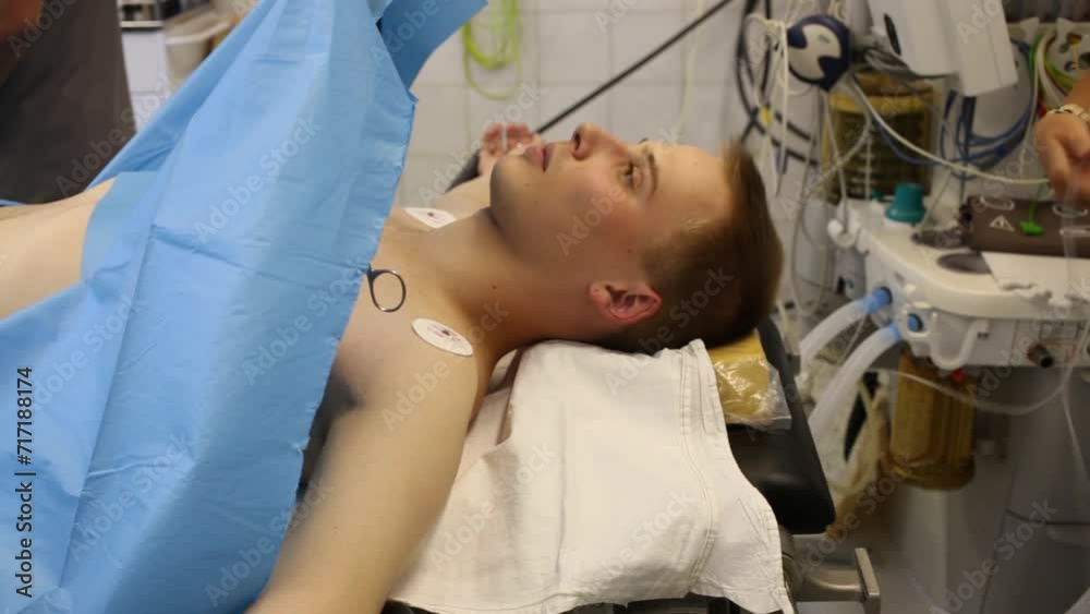 Young man lying on the operating table before surgery Young man lying on the operating table before surgery