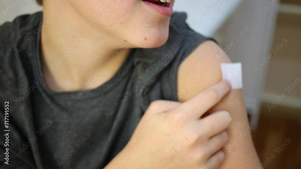 Boy holds disinfective cotton tampon at site of injection. Boy holds disinfective cotton tampon at site of injection.