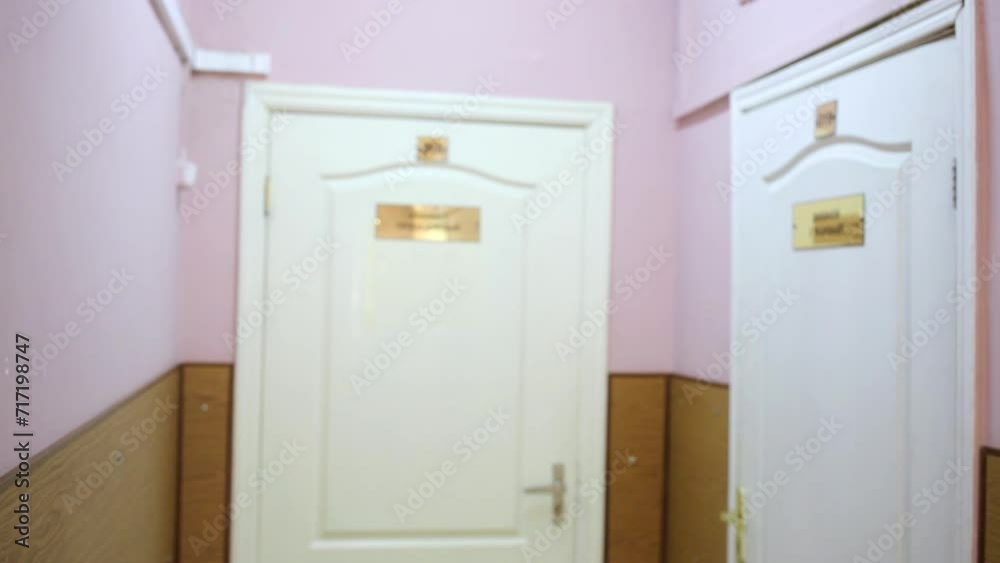 Female doctor in lab coat comes to room and closes door Female doctor in lab coat comes to room and closes door