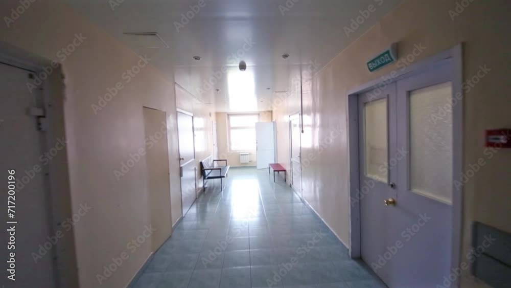 Movement in hallway with doors in hospital. Text on door, wall: exit Movement in hallway with doors in hospital. Text on door, wall: exit