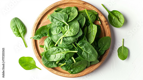 wooden round plate with fresh spinach leaves, top view
