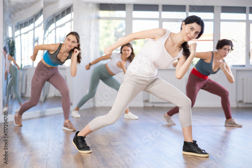 Group of women rehearsing hip hop dance moves in studio