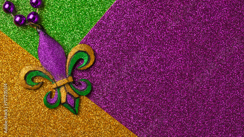 Mardi Gras beads with Fleur de lis, in glittering green, purple, and gold. Sparkling festive background for Mardi Gra in traditional colors. photo