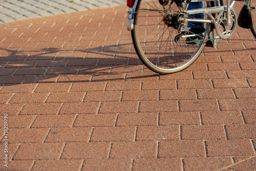 Fototapeta Naklejka Na Ścianę i Meble -  Selective focus of bicycle lane with blurred people on bike, The ground floor of small road or street for cyclist with bricks, Netherlands land of bicycle, Abstract transportation background.