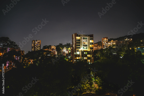 night photograph of el poblado medellin with apartment building in foreground with stars and mountains in background