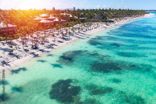 Sunset or sunrise on tropical beach with resorts, palm trees and caribbean sea. Dominican Republic. Aerial view photo