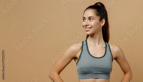 Young nice lady woman with slim body perfect skin stand hold hands on thigs looking aside on area isolated on plain pastel light beige background Lifestyle diet fit concept photo