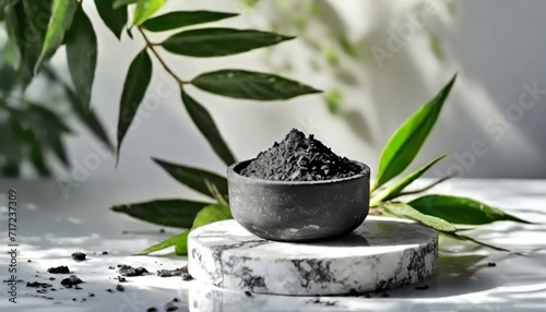 Presented on a white podium adorned with green leaves, the activated bamboo charcoal extract provides numerous advantages for the skin.