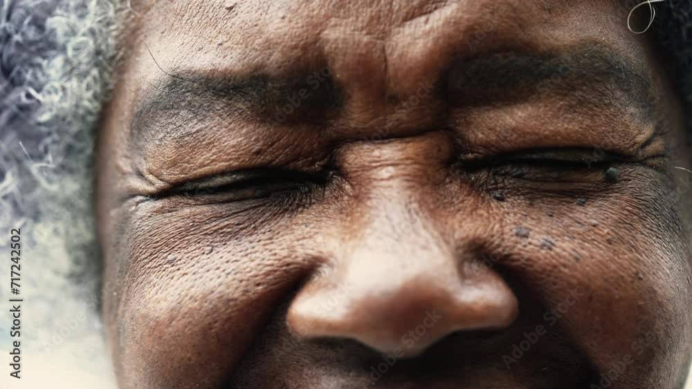 One peaceful wrinkled South American black woman closing eyes in meditation in macro closeup, opening eye staring at camera, detail face of elderly person in 80s One peaceful wrinkled South American black woman closing eyes in meditation in macro closeup, opening eye staring at camera, detail face of elderly person in 80s