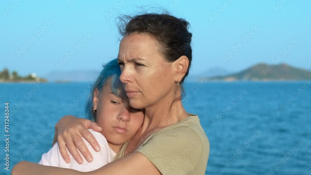 Mother hugs upset girl on beach. A pretty mother embrace her stylish sad teen on the sea shore during weekend time. Mother hugs upset girl on beach. A pretty mother embrace her stylish sad teen on the sea shore during weekend time.
